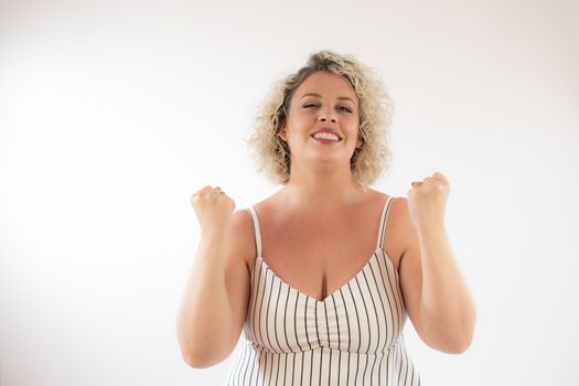 Blonde young woman making the winner gesture