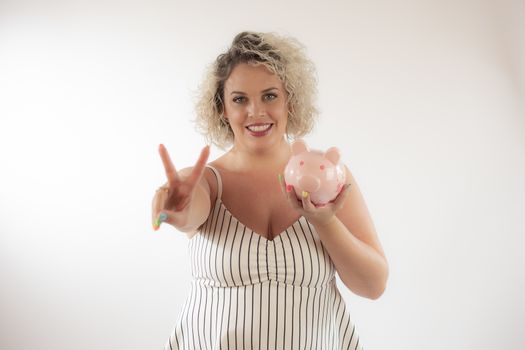 Blonde young woman with a piggy bank