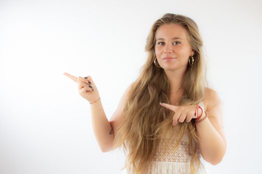 Pretty blonde girl in a white dress pointing with her fingers