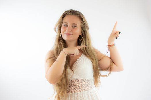 Pretty blonde girl in a white dress pointing with her fingers