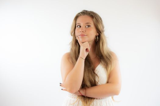 Pretty blonde girl in a white dress with the gesture of concern on her face