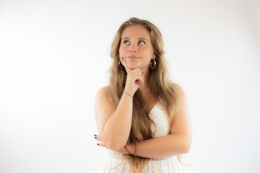 Pretty blonde girl in a white dress with the gesture of concern on her face