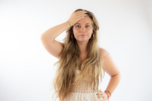 Pretty blonde girl in a white dress with the gesture of concern on her face