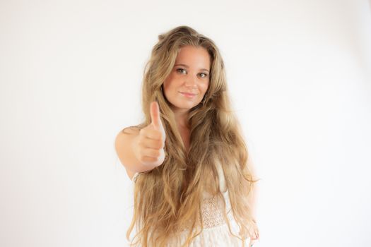 Pretty blonde girl in a white dress making finger up gesture