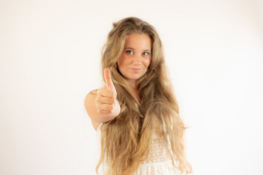 Pretty blonde girl in a white dress making finger up gesture