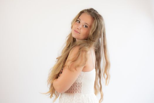 Portrait of a pretty blonde girl in a white dress