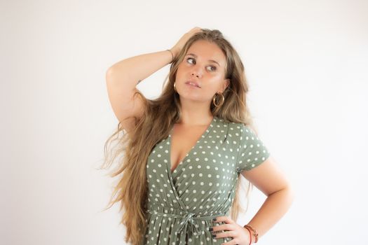 Pretty blonde girl in a green dress with the gesture of concern