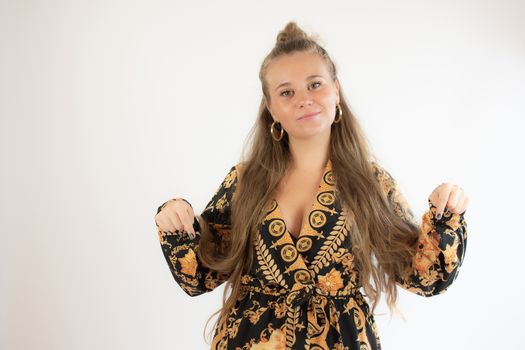 Pretty blonde girl in black gold dress pointing with her fingers