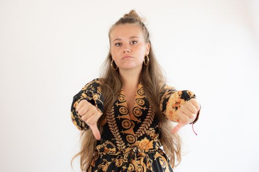 Pretty young girl in black dress making fingers down gesture