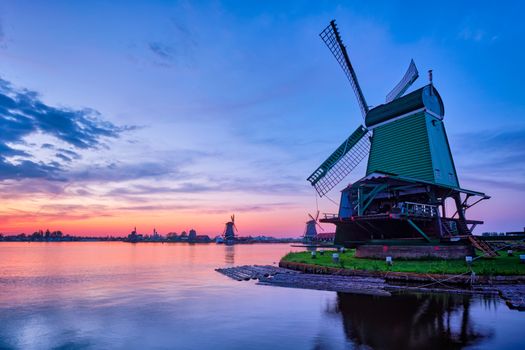 Netherlands rural scene - windmills at famous tourist site Zaanse Schans in Holland on sunset with dramatic sky. Zaandam, Netherlands