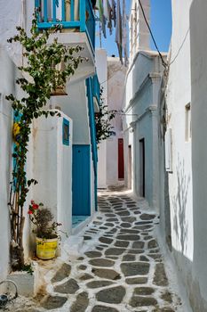 Picturesque scenic narrow Greek streets with traditional whitewashed houses with blue doors windows of Mykonos town in famous tourist attraction Mykonos island, Greece