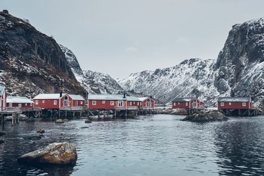 Nusfjord authentic traditional fishing village with traditional red rorbu houses in winter in Norwegian fjord. Lofoten islands, Norway