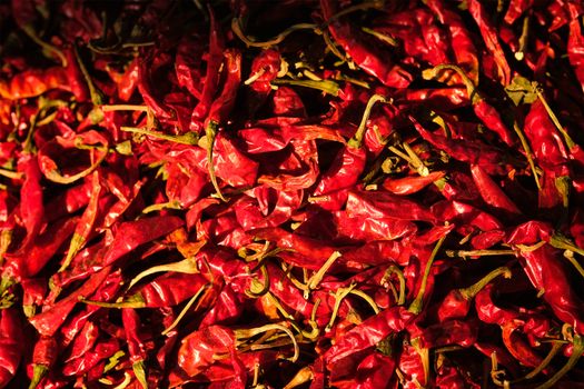 Dried dry red spicy chili peppers pile at asian market close up texture background. Sardar Market, Jodhpur, Rajasthan, India