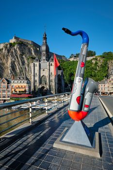 Picturesque Dinant town, Dinant Citadel and Collegiate Church of Notre Dame de Dinant and Charles de Gaulle bridge with saxophones as Dinant is hometown of saxophone inventor and flags. Namur, Blegium
