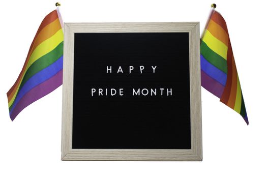 A Black Sign With a Birch Frame That Says Happy Pride Month in White Letters With Pride Flags Behind It on a Pure White Background