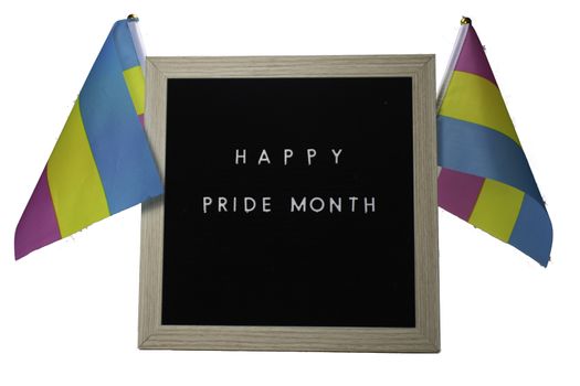 A Black Sign With a Birch Frame That Says Happy Pride Month in White Letters With Pride Flags Behind It on a Pure White Background