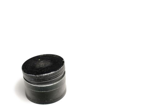 A Black and Used Marijuana Grinder With the Lid Losely Closed
