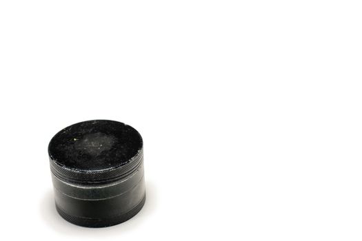 A Black and Used Marijuana Grinder With the Lid Tightly Closed