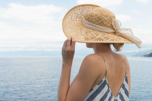 Beautiful, romantic blonde woman relaxeing on summer vacations traveling by cruse ship ferry boat. Summer vacation lifestyle.