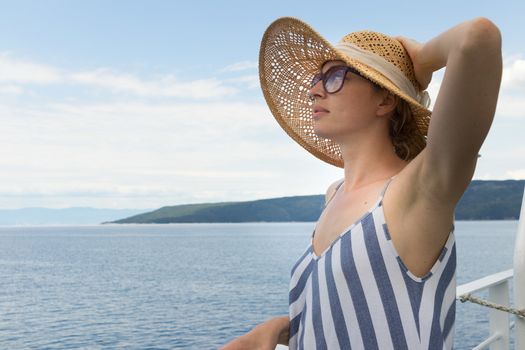 Beautiful, romantic blonde woman relaxeing on summer vacations traveling by cruse ship ferry boat. Summer vacation lifestyle.