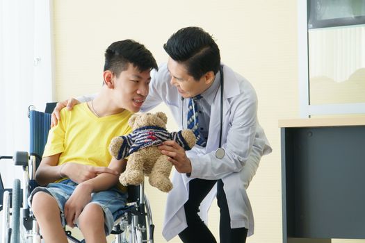 Asian doctors, adult men talking to patients with boy disabled in wheelchairs. Counseling and rehabilitation in disability in hospitals. Technology and modern medical science