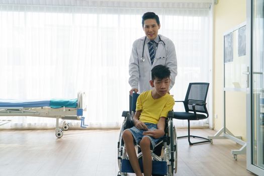 Asian doctors, adult men talking to patients with boy disabled in wheelchairs. Counseling and rehabilitation in disability in hospitals. Technology and modern medical science