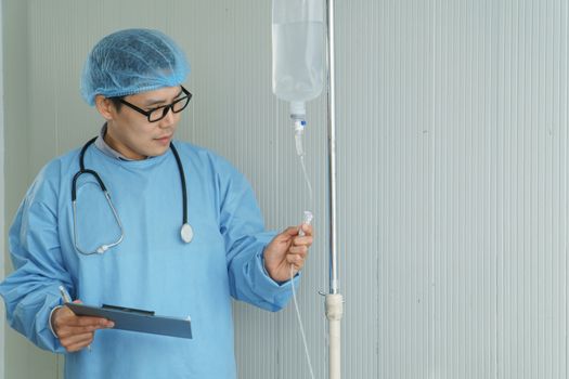 Portrait of a professional surgeon, an Asian man carrying a saline bag, operating in an emergency room. Modern medical technology and science. Concepts of care and rehabilitation in hospital patients.