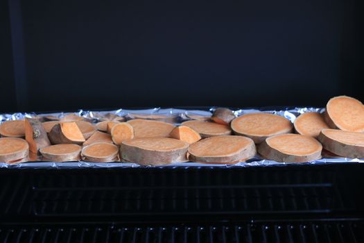 Roasted sweet potatoes with rosemary on the grill pan on the table close-up. horizontal view from above. High quality photo
