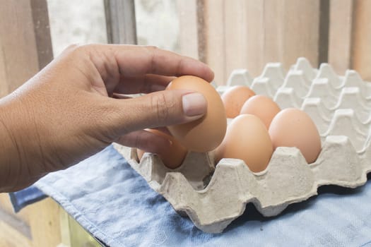Man hand holding egg in kitchen
