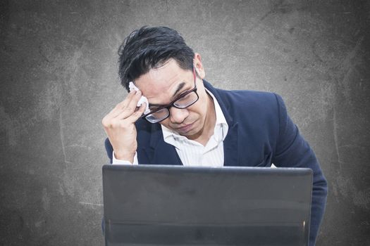 Tired business man with glasses wiping his forehead,A man is working harder to achieve new sales target.