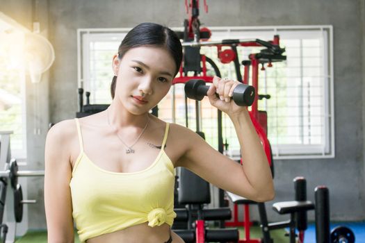 Young asian woman holding dumbell, healthy concept, sport