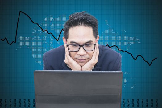 Asian business man looking laptop on business graph