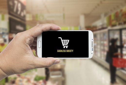 Hand holding smart phone with mobile payment in super market ,Cashless society concept.