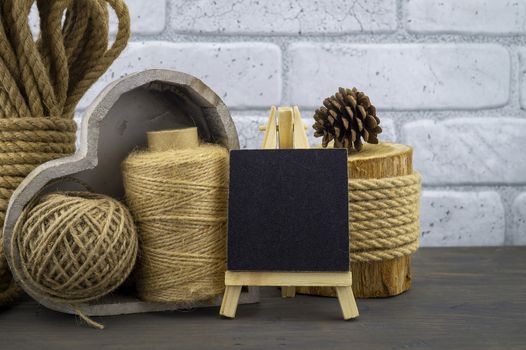 Assorted balls of hemp twine and string with skeins of rope and slate chalkboard in a close up rustic still life