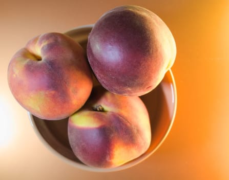 ripe peaches on a light yellow background, top view