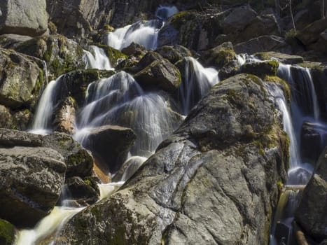 long exposure waterfall Velky Stolpich in Jizerske hory, Jizera mountain, forest on Cerny Stolpich black creek in czech republic, green mossed stones and ferns