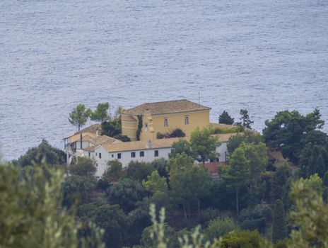close up aerial view on Monastary Panagias Paleokastritsa near popular turquoise beach of Agios Spyridonas, Corfu island, Ionian, Greece.