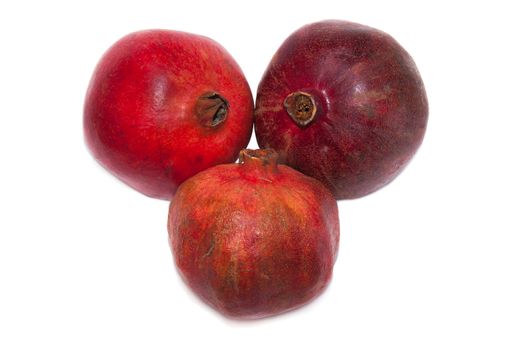 on a white background three ripe pomegranate fruit