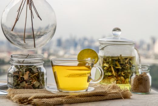 Refreshing and enjoy with A cup of lemongrass pandan tea served with brown sugar In the afternoon on beautiful city view. Thai herbal plant and healthy drinks concept. Selective focus, Copy space.