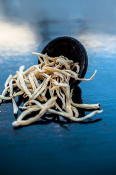 Popular Indian &amp; Asian ayurvedic organic herb musli Safed Moosli/ Shaqaqule/ Dholi Musli/ Khiruva/ Shedheveli/ Swetha Musli/ Taniravi Thang/ in a clay bowl on wooden surface.