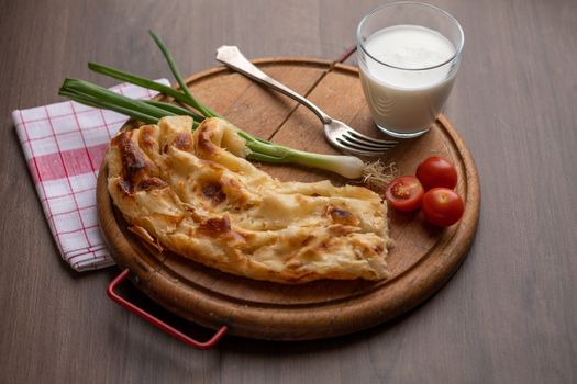 Traditional balkan breakfast - Borek or Burek pie with cheese aranged on wooden table