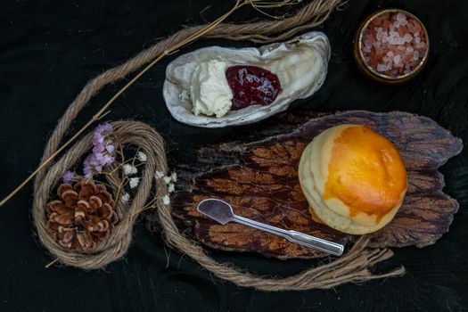 Traditional french sweet dessert : Scones on the wooden tray served with Homemade raspberry jam and Mascarpone cheese on Shell. Delicious seasonal breakfast. Selective focus.