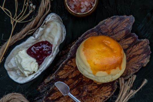 Traditional french sweet dessert : Scones on the wooden tray served with Homemade raspberry jam and Mascarpone cheese on Shell. Delicious seasonal breakfast. Selective focus.