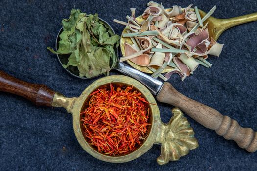 Wonderful Thai herbal tea with Dried lemongrass herb, indian marsh fleabane and safflower on spoons. Selective focus.