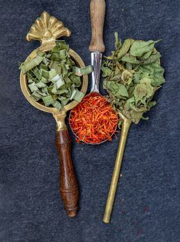 Wonderful Thai herbal tea with Dried pandan herb, indian marsh fleabane and safflower on spoons. Selective focus.