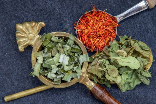 Wonderful Thai herbal tea with Dried pandan herb, indian marsh fleabane and safflower on spoons. Selective focus.