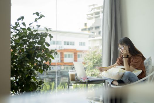 Teen girl using computer laptop to self study online at home. Online learning, e-learning, self study and online education concept.