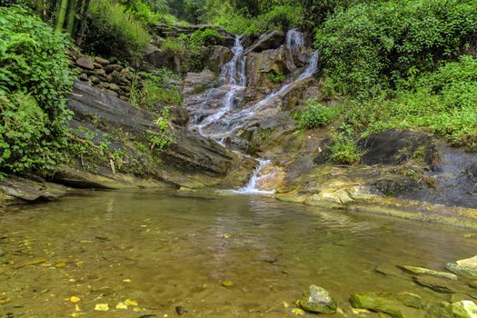 Waterfall cascade in jungle tropical rainforest rock mountain river motion blur
