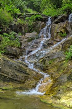 Waterfall cascade in jungle tropical rainforest rock mountain river motion blur