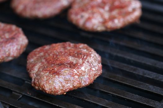 Several minced steaks on the grill